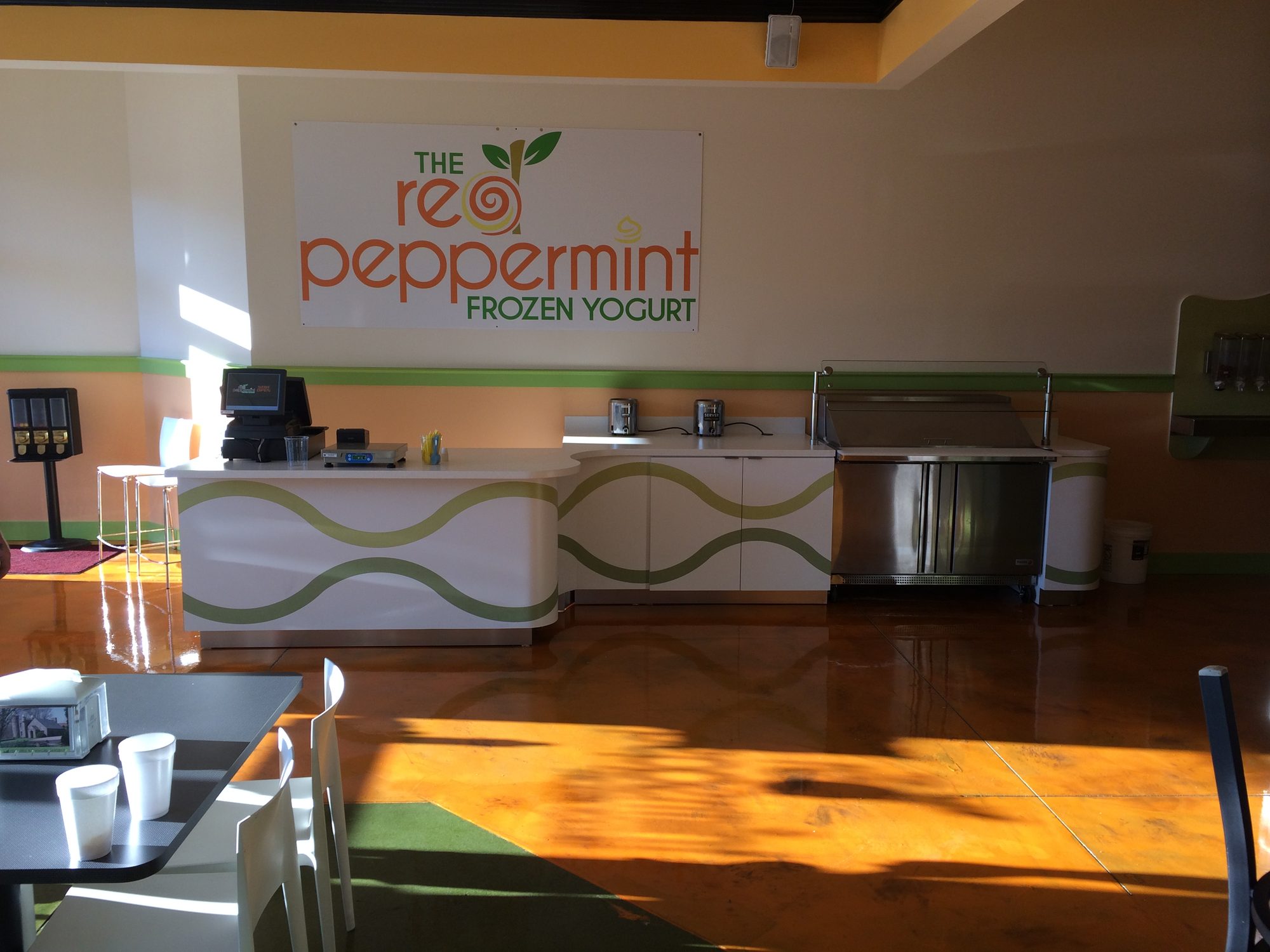 Retail service counter in white solid surface with an inlaid green wave pattern